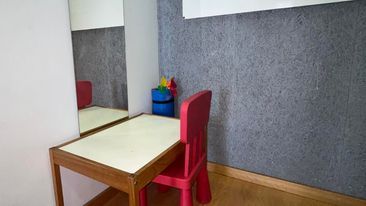 Detalle de sala con mesita en el rincón y silla infantil de color fuxia
